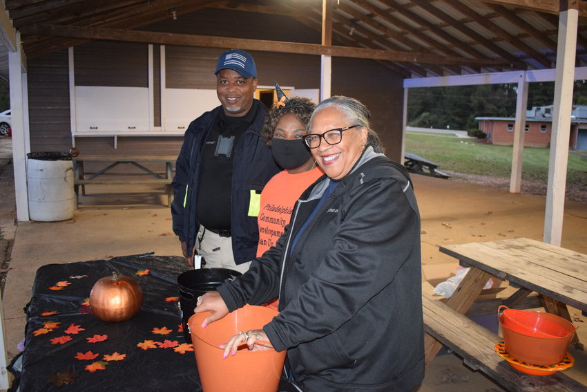 Philadelphia Police Department employees Sgt. Brad Crockett, Lt. Adriana Peeples and Telecommunications Supervisor Elsie Kirksey hand out candy to children Saturday night at Westside Park for the Westside Kids Night Out Trick-or-Treat event.